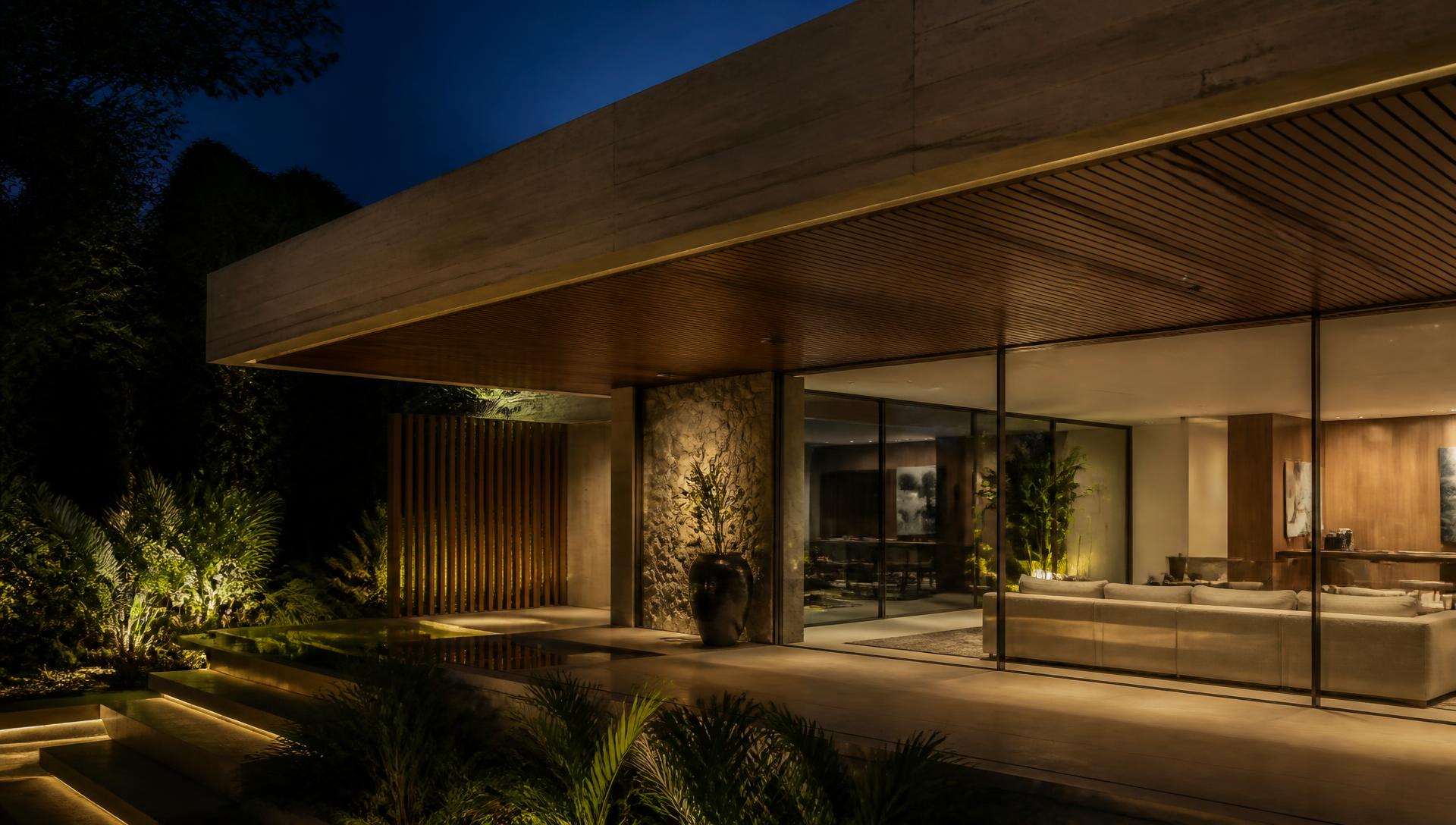 Residência contemporânea com iluminação quente integrada à arquitetura